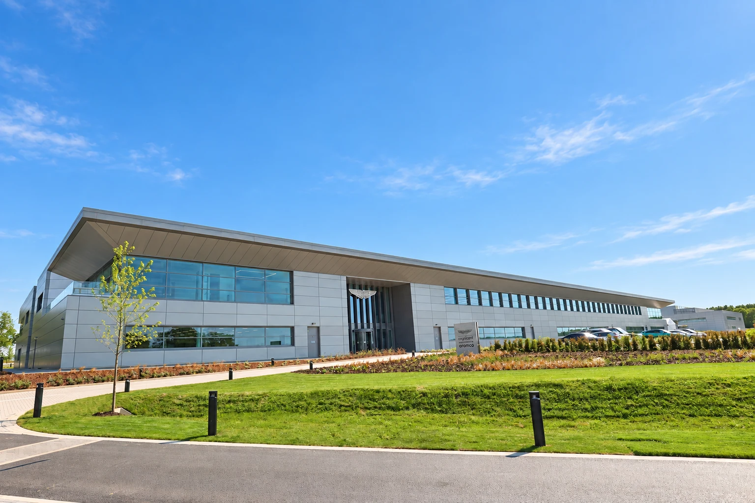 Instalaciones del campus de Aston Martin Formula One bajo un cielo azul soleado.